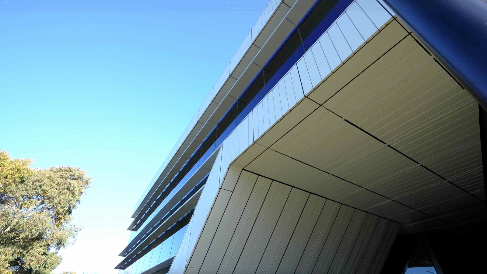 East Edge 2 angular cantilevered facade looking upward against clear blue sky - architectural detail