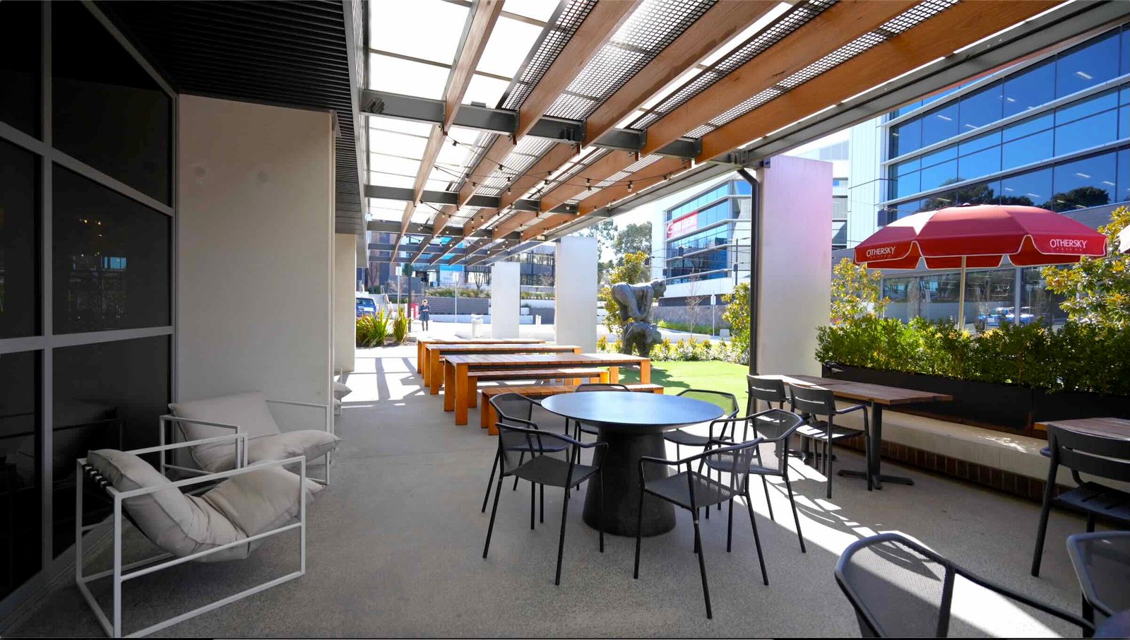 East Edge 2 building entrance with EV charging stations, paved pathway and landscaped garden beds